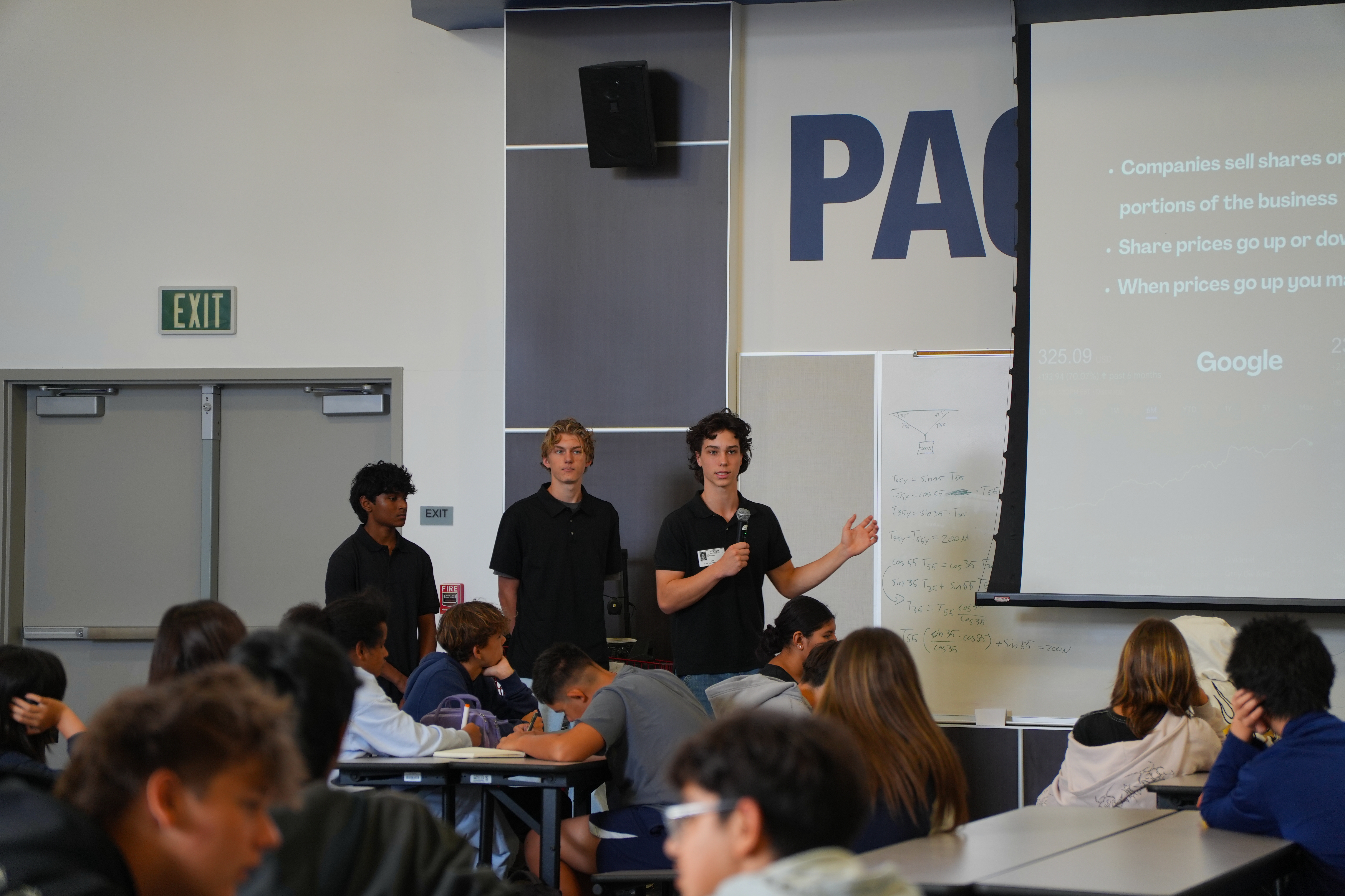 FLI members teaching from the front of a classroom