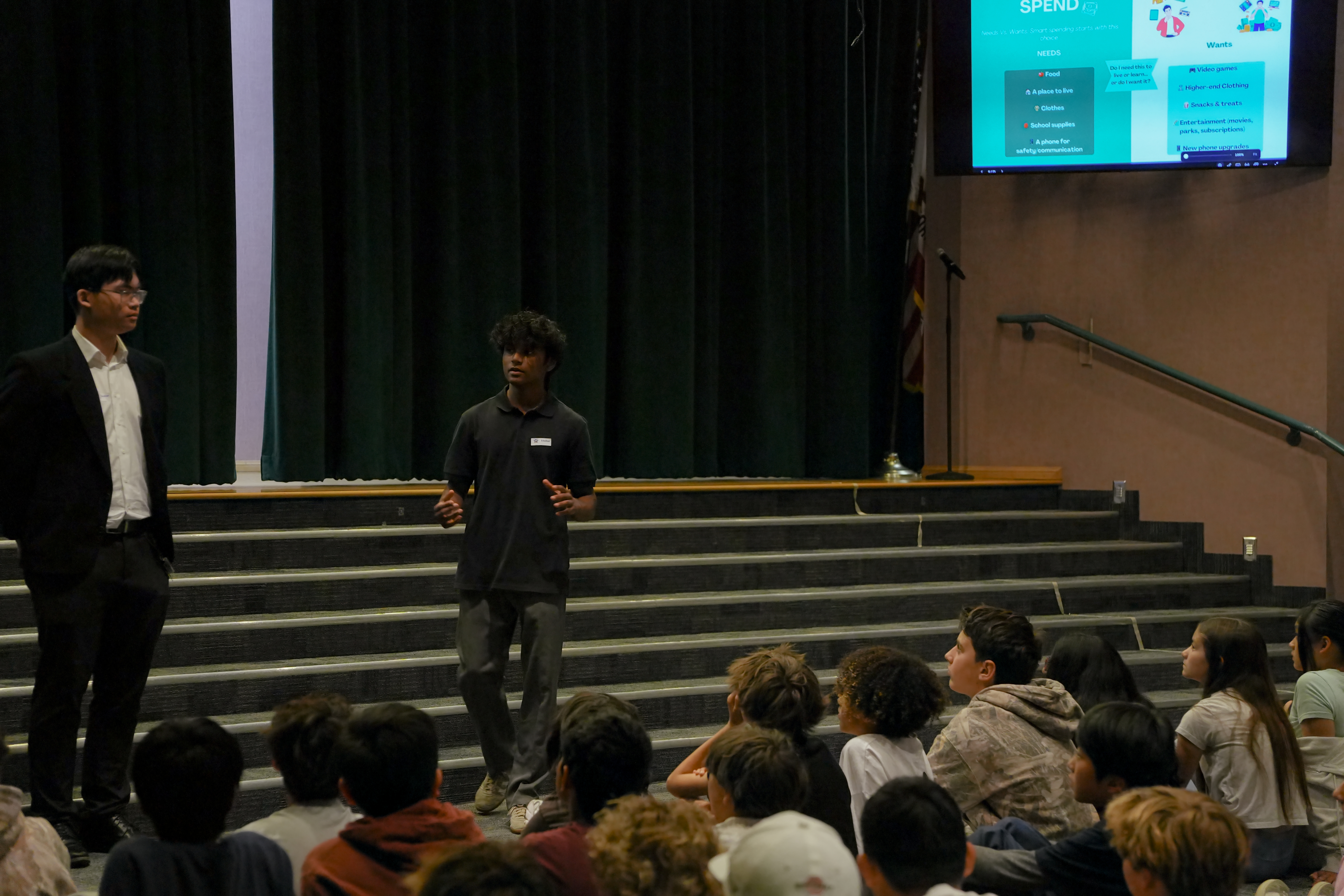 FLI member presenting to student audience in auditorium